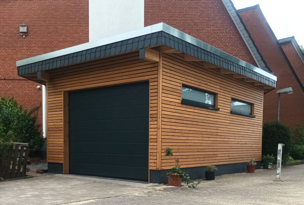 Carport mit Holzfassade und Sektionaltor von Derus Holzbau